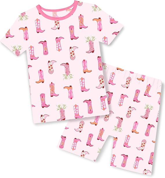 Pink short-sleeve pajama set with a pattern of colorful cowboy boots and small green plants. The top and shorts both feature the same playful boot design on a light pink background.