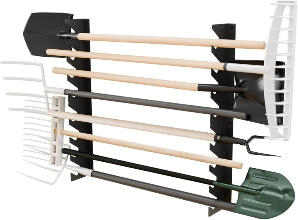 A black wall-mounted rack holds various garden tools with wooden handles, including shovels, rakes, and a hoe, organized horizontally against a white background.