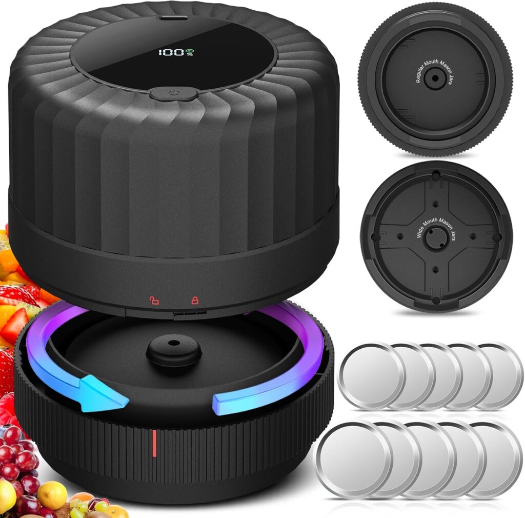 A black, cylindrical vacuum sealer with a digital display is shown open, along with multiple silver lids, two sealing bases, and assorted fruit beside it. The device has LED lights and a modern design.