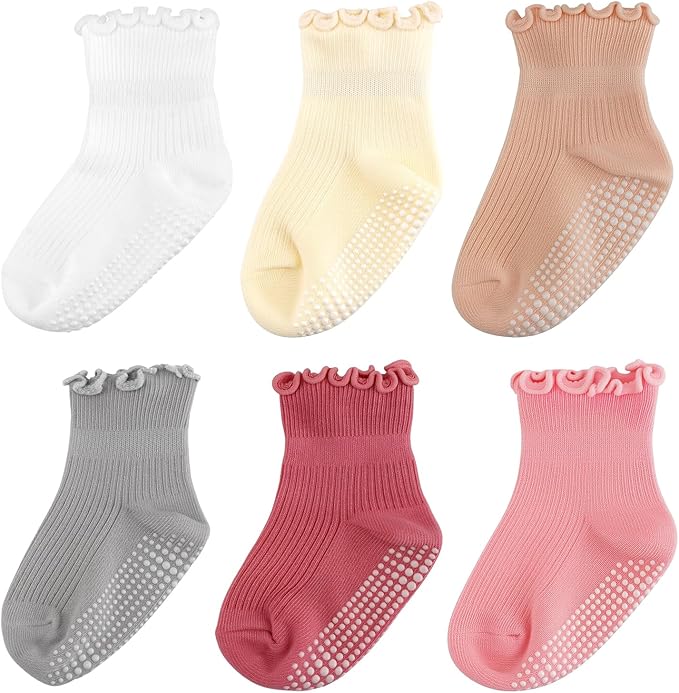 Six pairs of ribbed ankle socks in white, yellow, beige, gray, red, and pink with ruffled cuffs and non-slip grips on the soles, arranged in two rows against a white background.