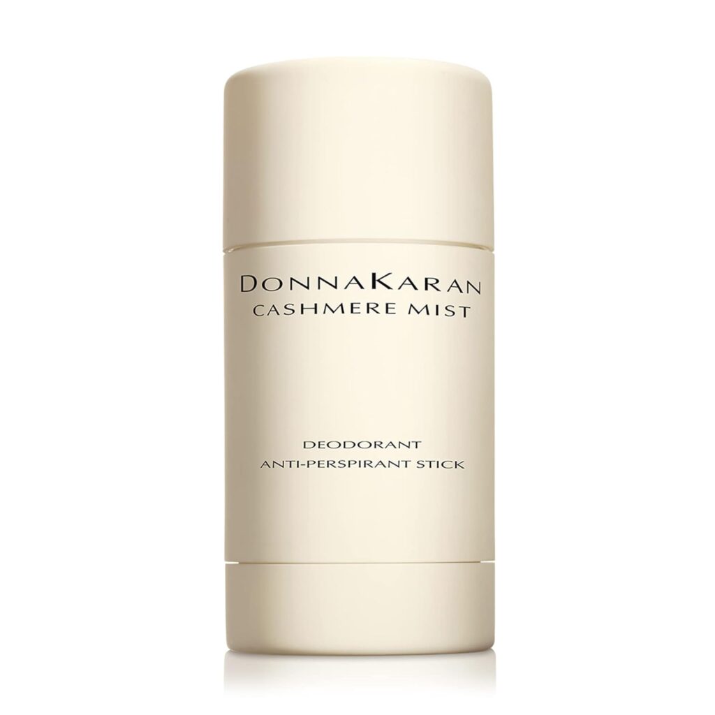 A beige cylindrical Donna Karan Cashmere Mist deodorant and anti-perspirant stick with simple black text on the front against a white background.