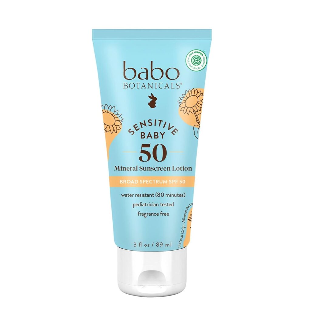A blue and yellow tube of Babo Botanicals Sensitive Baby Mineral Sunscreen Lotion SPF 50, featuring sunflower illustrations and details such as "broad spectrum," "fragrance free," and "pediatrician tested.