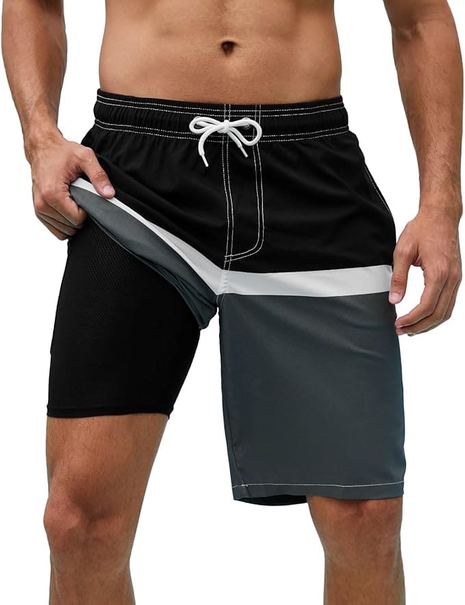 A man wears color-block swim trunks with a drawstring waist and lifts one side to show a black inner compression liner beneath the outer shorts.
