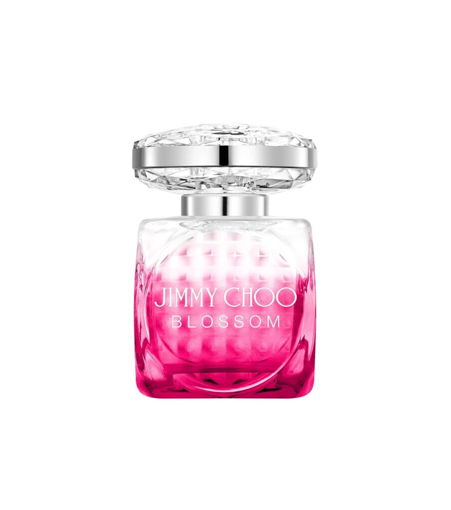 A clear glass bottle of JIMMY CHOO Blossom EDP with a gradient pink base, silver accents, and a faceted clear cap. The brand name and "Blossom" are printed in white, representing premium beauty in every detail.