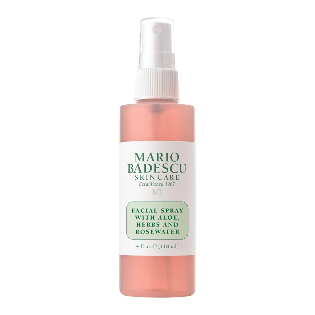 A clear spray bottle of Mario Badescu Facial Spray with Aloe, Herbs, and Rosewater, featuring a white label with green text and a white spray top. The liquid inside is pink—perfect for refreshing your skin and scoring big on Thursday Deals.