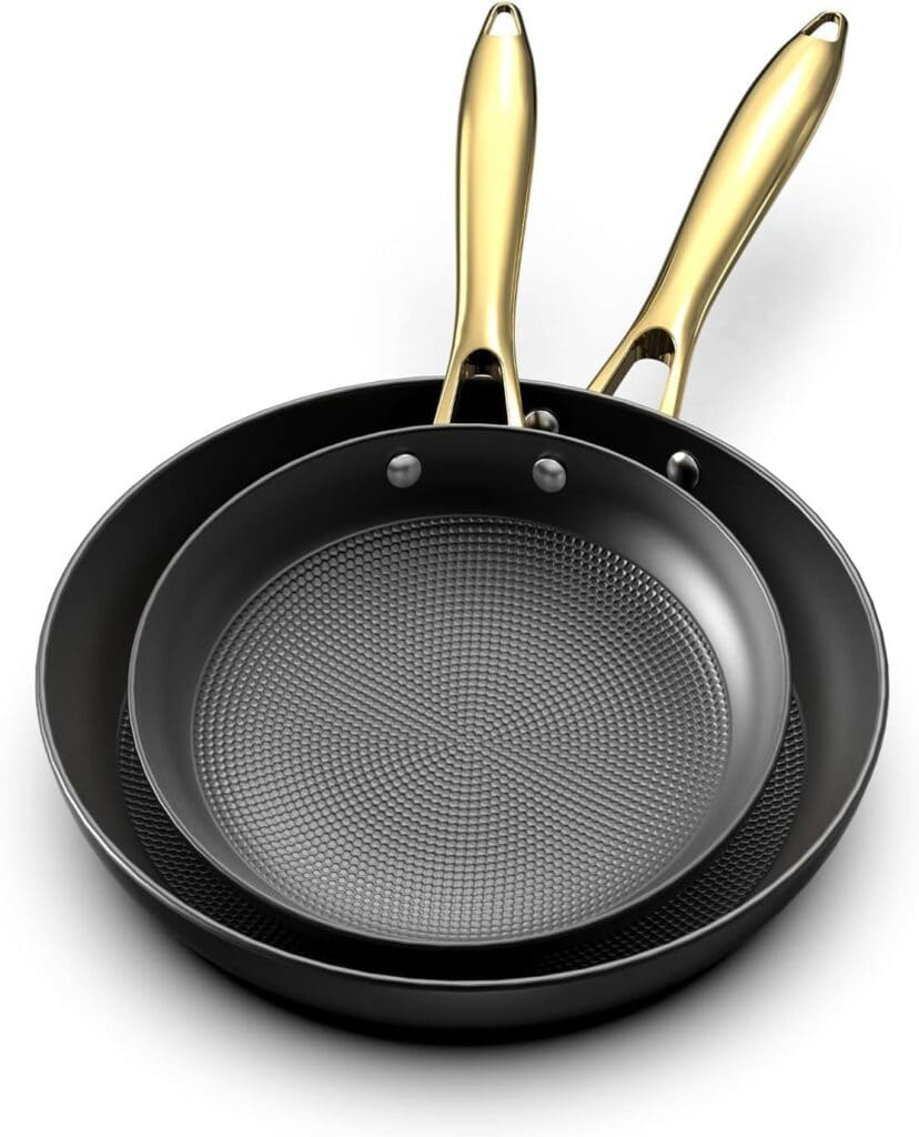 Two black frying pans with textured cooking surfaces are stacked together. Each pan has a shiny gold-colored handle. The pans are viewed from above on a white background.