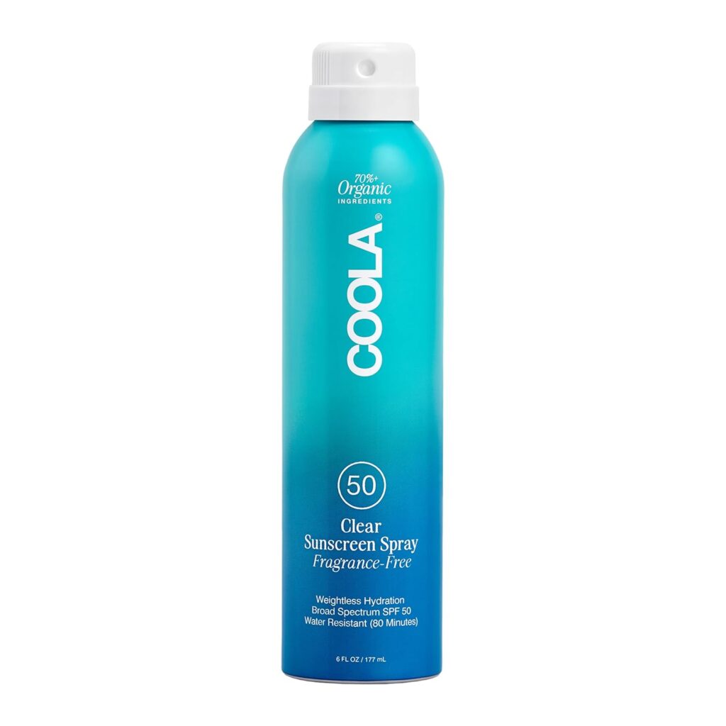 A blue ombre spray can of COOLA Clear Sunscreen Spray SPF 50, labeled as fragrance-free, organic, and water resistant for 80 minutes. The bottle has a white cap and text detailing its features.