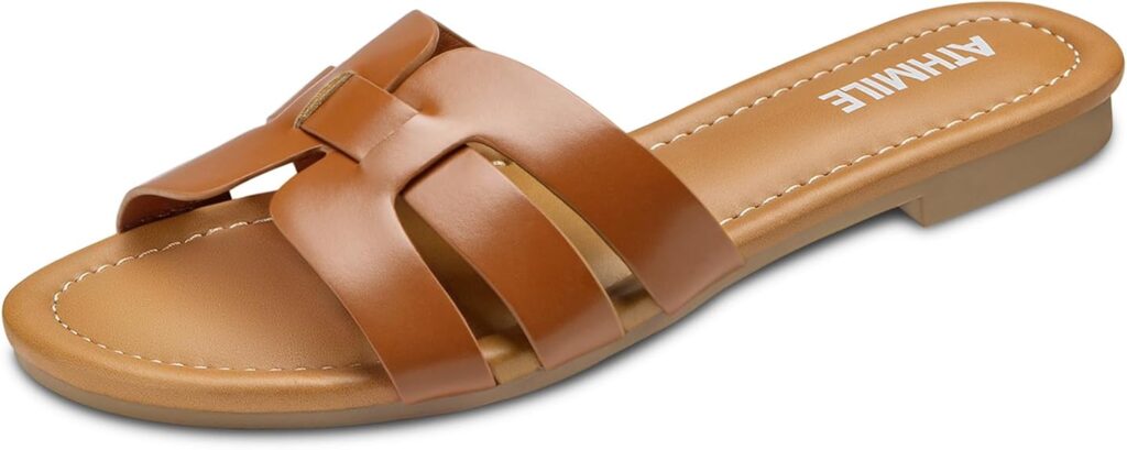 A brown flat slip-on sandal with an open toe, featuring wide crisscross leather straps and visible stitching around the padded insole. Enjoy added comfort and style—perfect for snagging during Friday Deals. "ATHMILE" is printed on the footbed near the heel.
