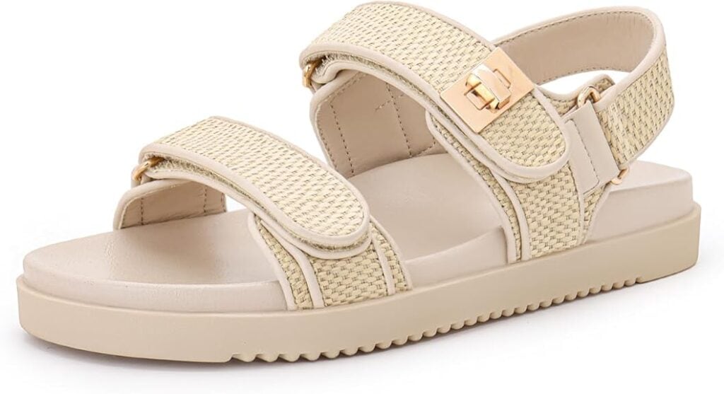 Beige sandal with woven textured straps, velcro closures, gold buckle accent, cushioned footbed, and flat ridged sole—perfect for summer style. Shop now and save with Friday Deals! Shown on a white background.