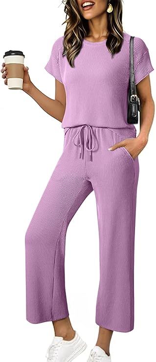 A woman wearing a lavender Women's Ribbed Knit Set with a drawstring waist, white sneakers, and a shoulder bag, holding a coffee cup and smiling. Shop this comfy Two Piece Set now for 63% off!.