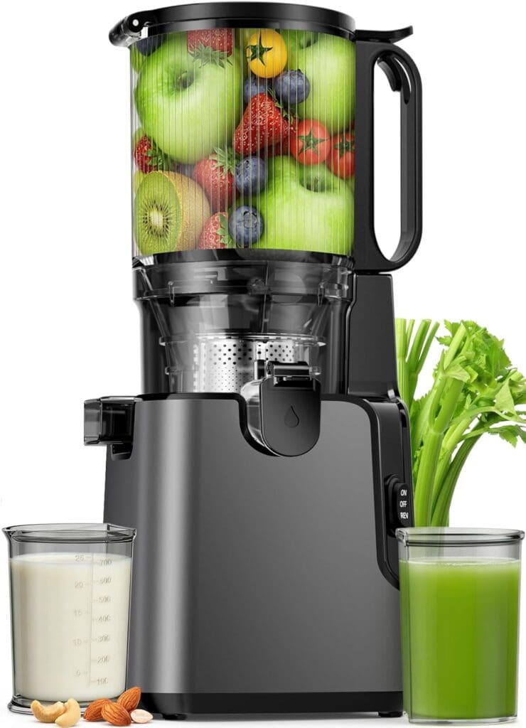 A black Juicer Machine filled with apples, strawberries, kiwi, and blueberries stands on a counter. Next to it are a glass of green juice, nut milk, almonds, cashews, and fresh celery stalks—perfect for the Juicer Machine Sale.