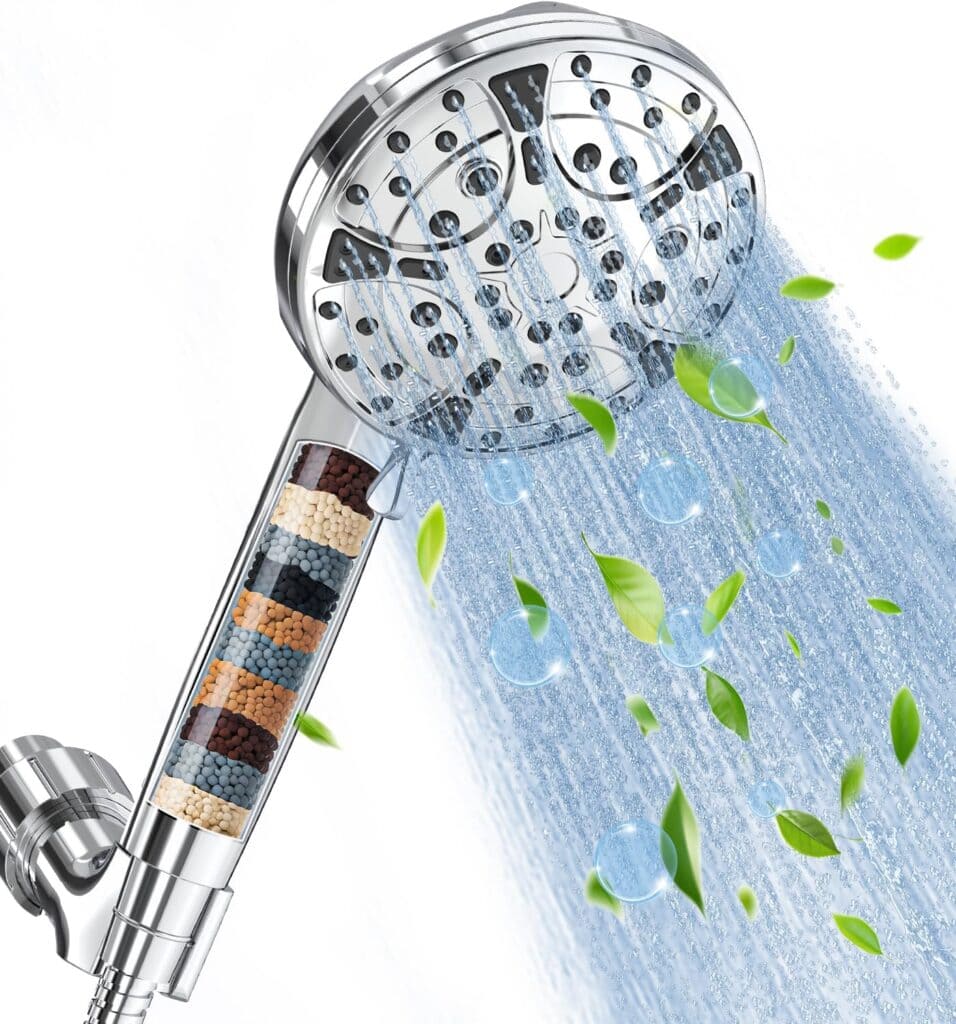 A handheld shower head with a built-in filter displaying layers of minerals and beads. Water sprays from the head, accompanied by floating green leaves and blue bubbles, symbolizing purification and freshness.