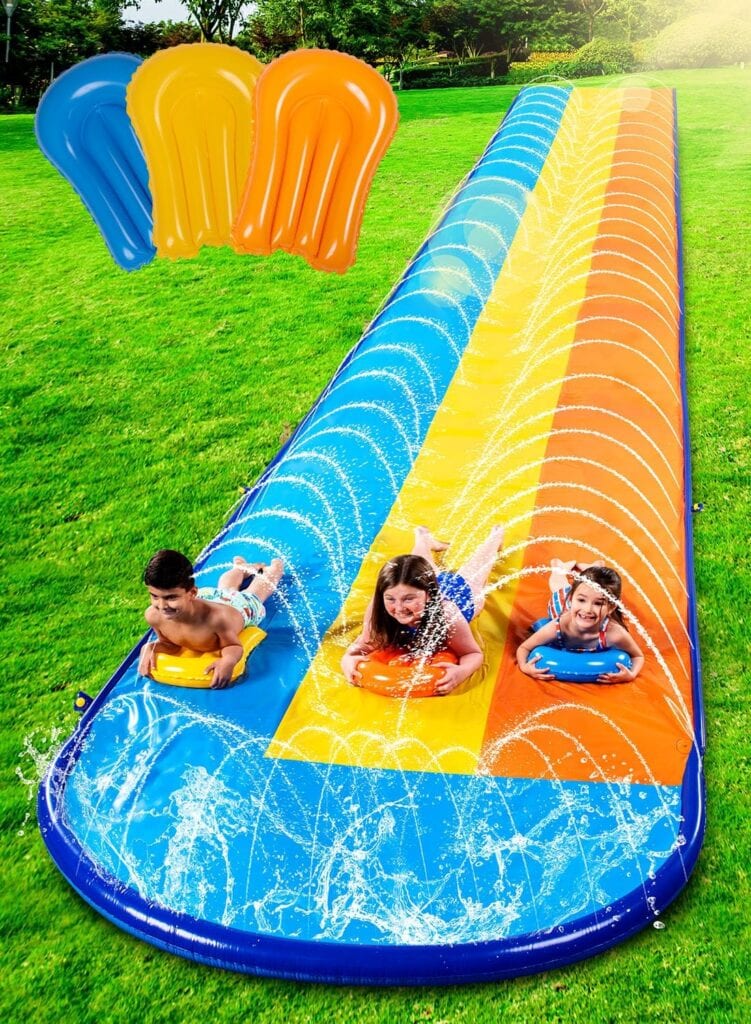 Three children enjoy a colorful outdoor water slip-and-slide with blue, yellow, and orange lanes, using matching inflatable boards. Water sprays upward along the sides. Perfect for summer fun—check out Friday Deals to make this slide yours!.