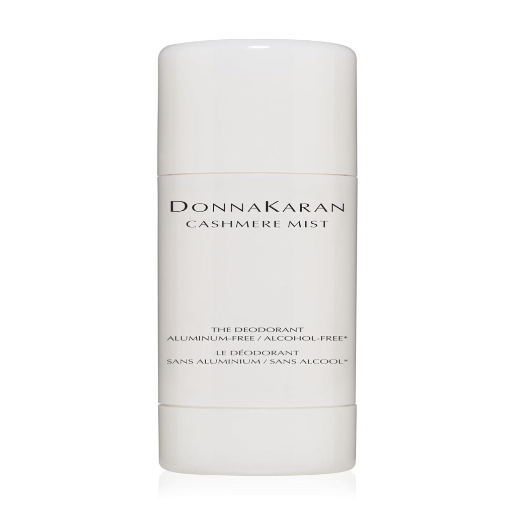 A white cylindrical container of Donna Karan Cashmere Mist deodorant, featuring simple black text with product name and details, including aluminum-free and alcohol-free properties, on a clean white background.