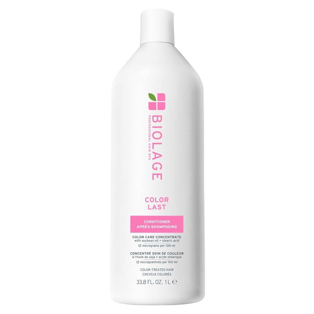 A white bottle of Biolage Color Last Conditioner with a pink label, green leaf logo, and text indicating it is for color-treated hair. The bottle size is 33.8 fl oz (1 liter).