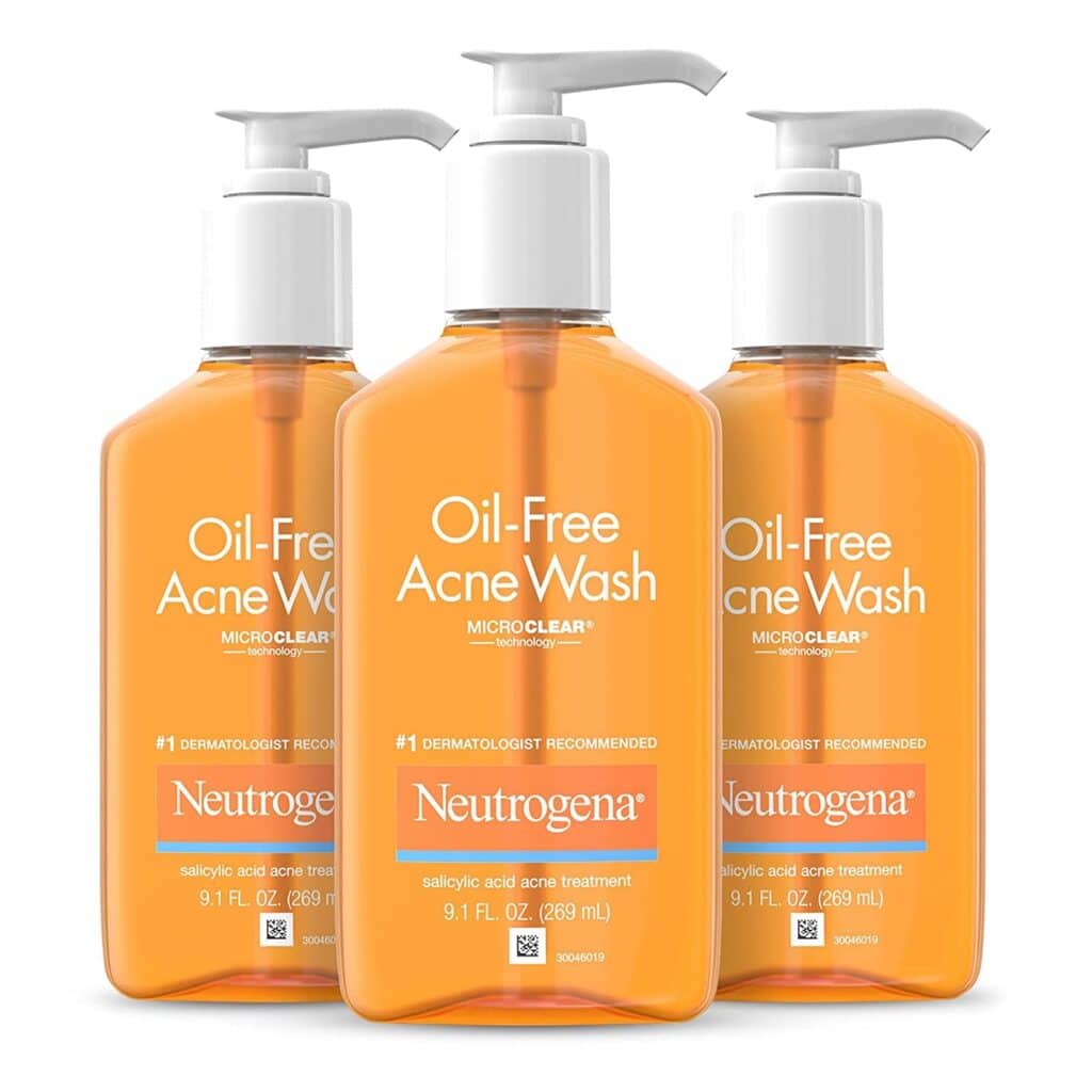 Three bottles of Neutrogena Oil-Free Acne Wash with pump dispensers, featuring orange liquid and white labels highlighting salicylic acid acne treatment, each containing 9.1 fl oz (269 mL).