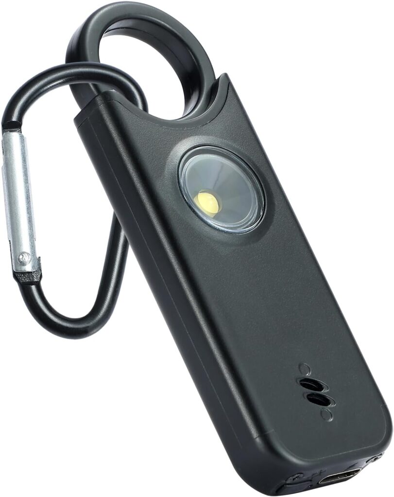 A black portable LED flashlight with a built-in carabiner and a round light at the center, designed for easy attachment to bags or keychains.