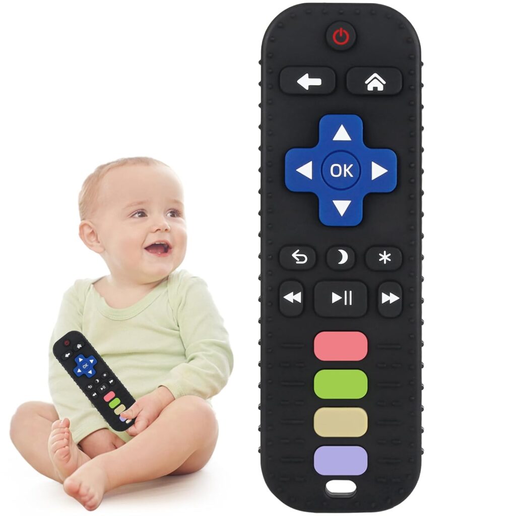 A smiling baby in a green onesie sits on the floor holding an oversized toy remote control, with a close-up view of the remote shown in front.