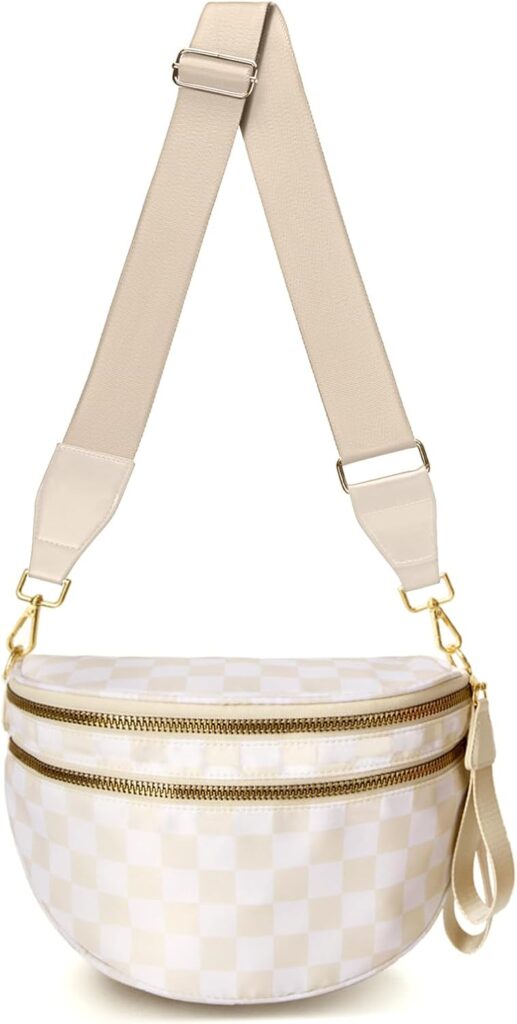A beige crossbody bag with a wide adjustable strap, gold hardware, and two zippered compartments. The bag features a subtle checkered pattern in light beige and white tones.