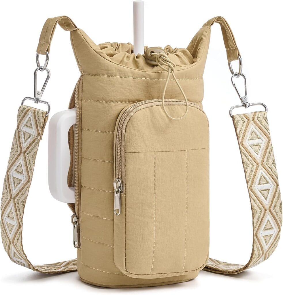 A beige quilted water bottle holder with a front zip pocket, decorative geometric-patterned strap, drawstring closure, and a side slot holding a white handle.