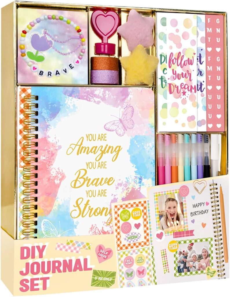 A colorful DIY journal set with a spiral notebook, markers, stickers, a beaded bracelet, heart-shaped stamp, glitter, fluffy star, and decorative cards—arranged neatly in a gold-edged box. Perfect for creative fun and Wednesday Deals!.