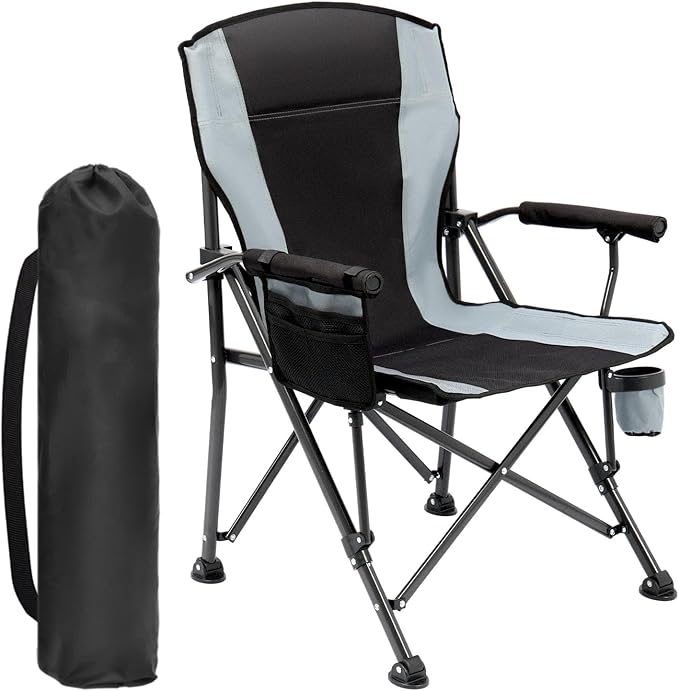 A black and gray folding camping chair with armrests, a cup holder, side pocket, and a matching black carrying bag standing upright beside it.