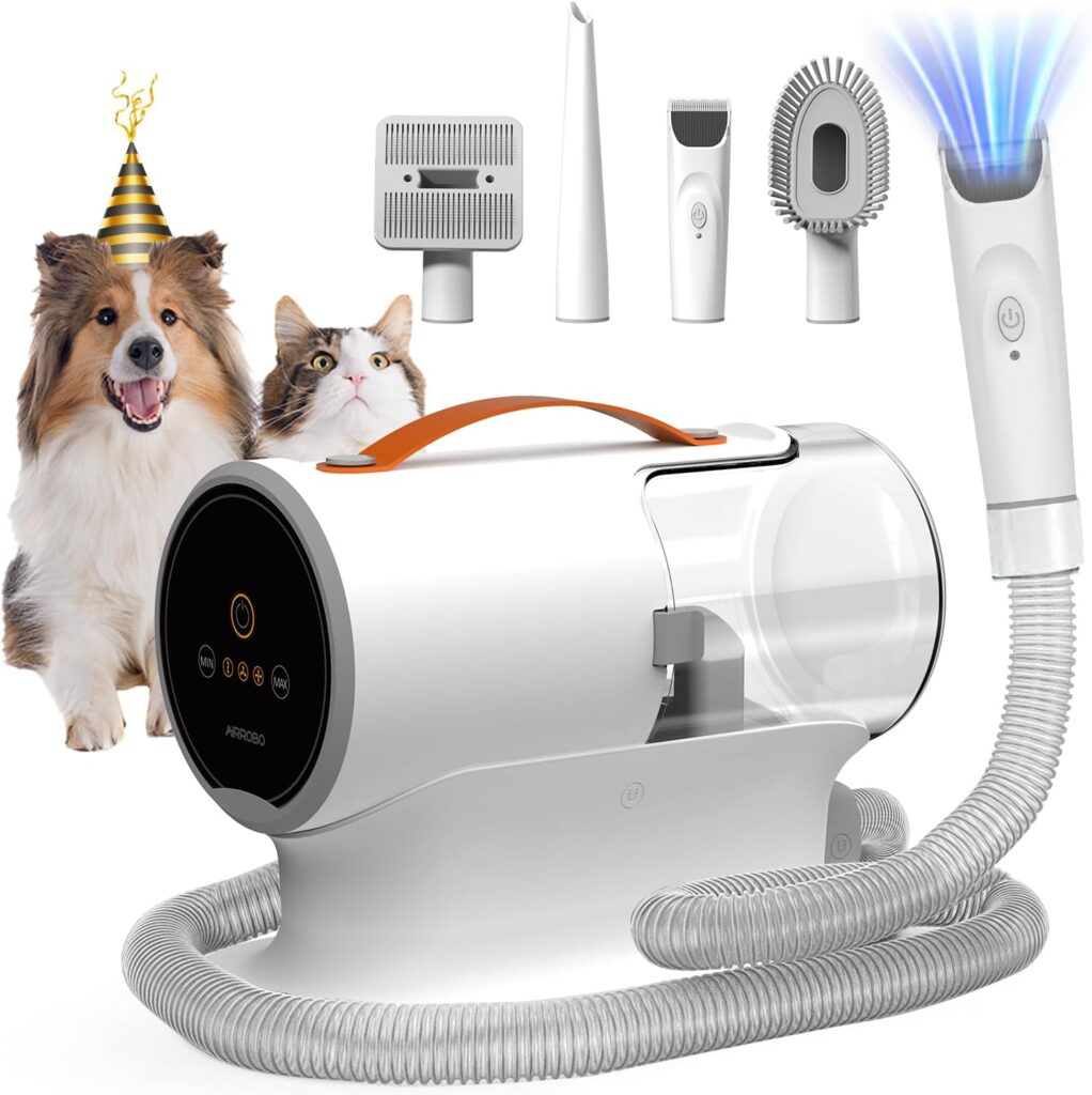 A pet grooming vacuum kit with hose, various grooming attachments, and a main unit. A dog and a cat, both looking up, are shown to the left, with the dog wearing a party hat. Blue light emits from one attachment.