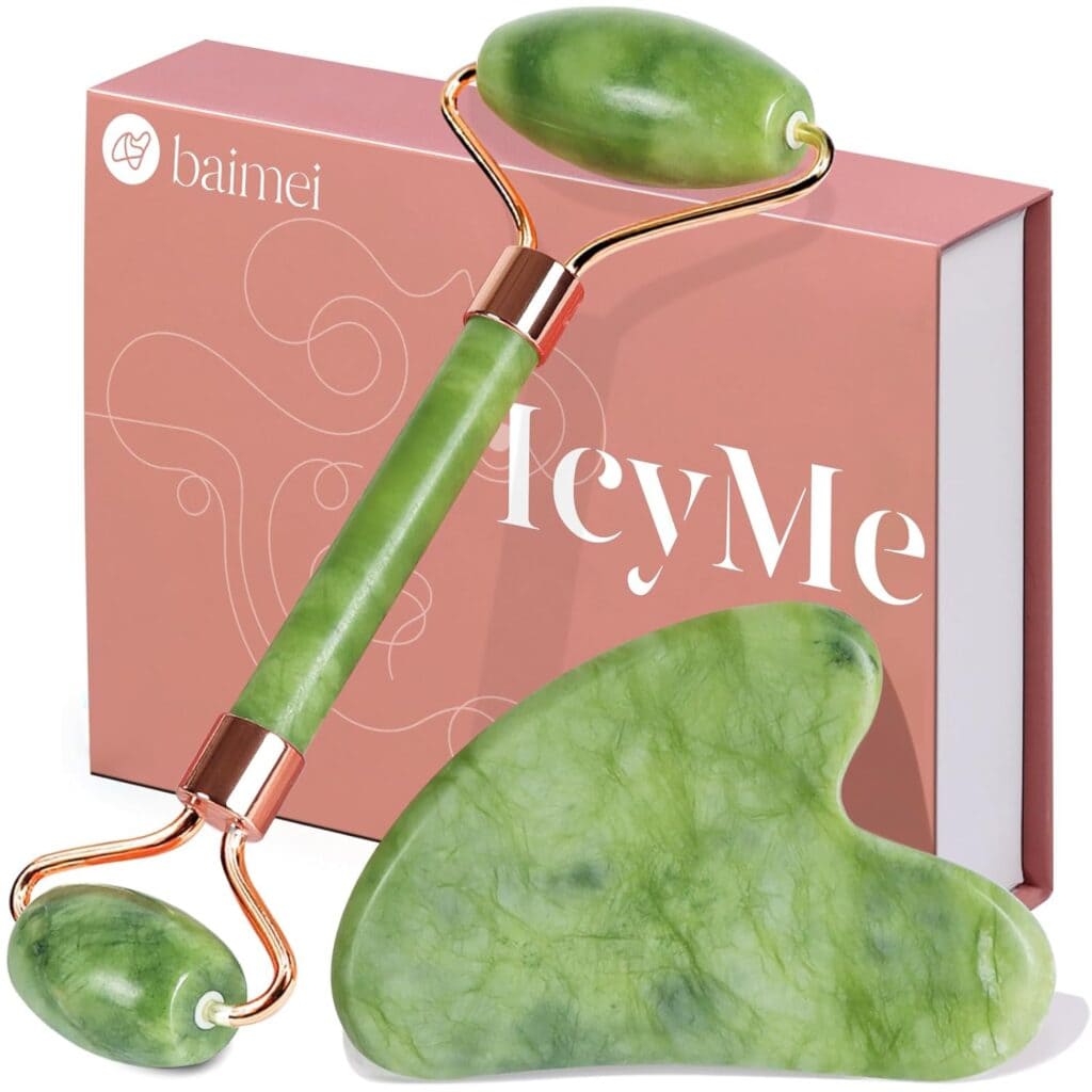 A green jade roller and a matching gua sha tool are displayed in front of a pink box labeled "baimei" and "HeyMe." The tools have gold-colored accents and are used for facial massage and skincare.