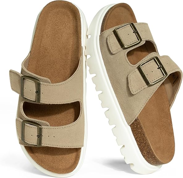 A pair of beige suede sandals with two adjustable buckle straps and white chunky soles. The footbed is contoured and brown, providing support and comfort.