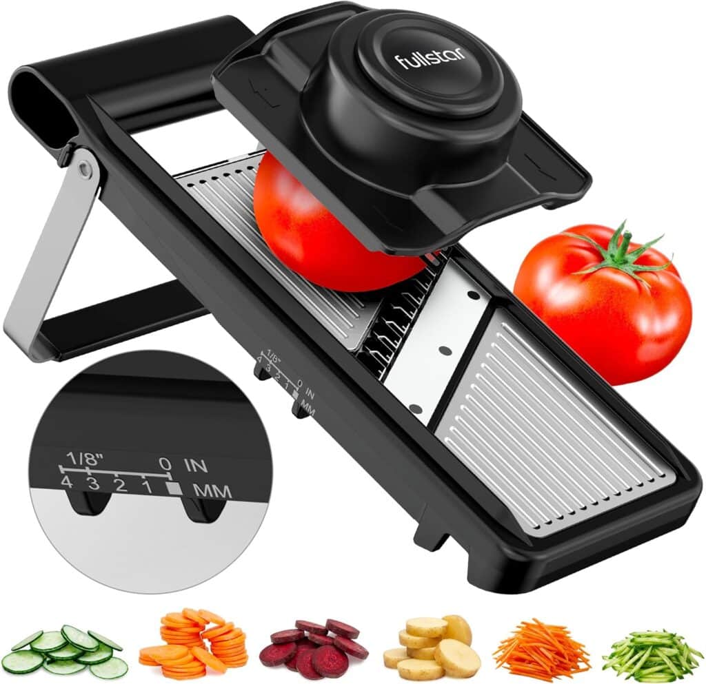 A black adjustable mandoline slicer with a tomato being sliced, a whole tomato beside it, and sliced vegetables including carrots, cucumber, beet, and potato displayed below—perfect for your kitchen and available now in our Monday Deals.