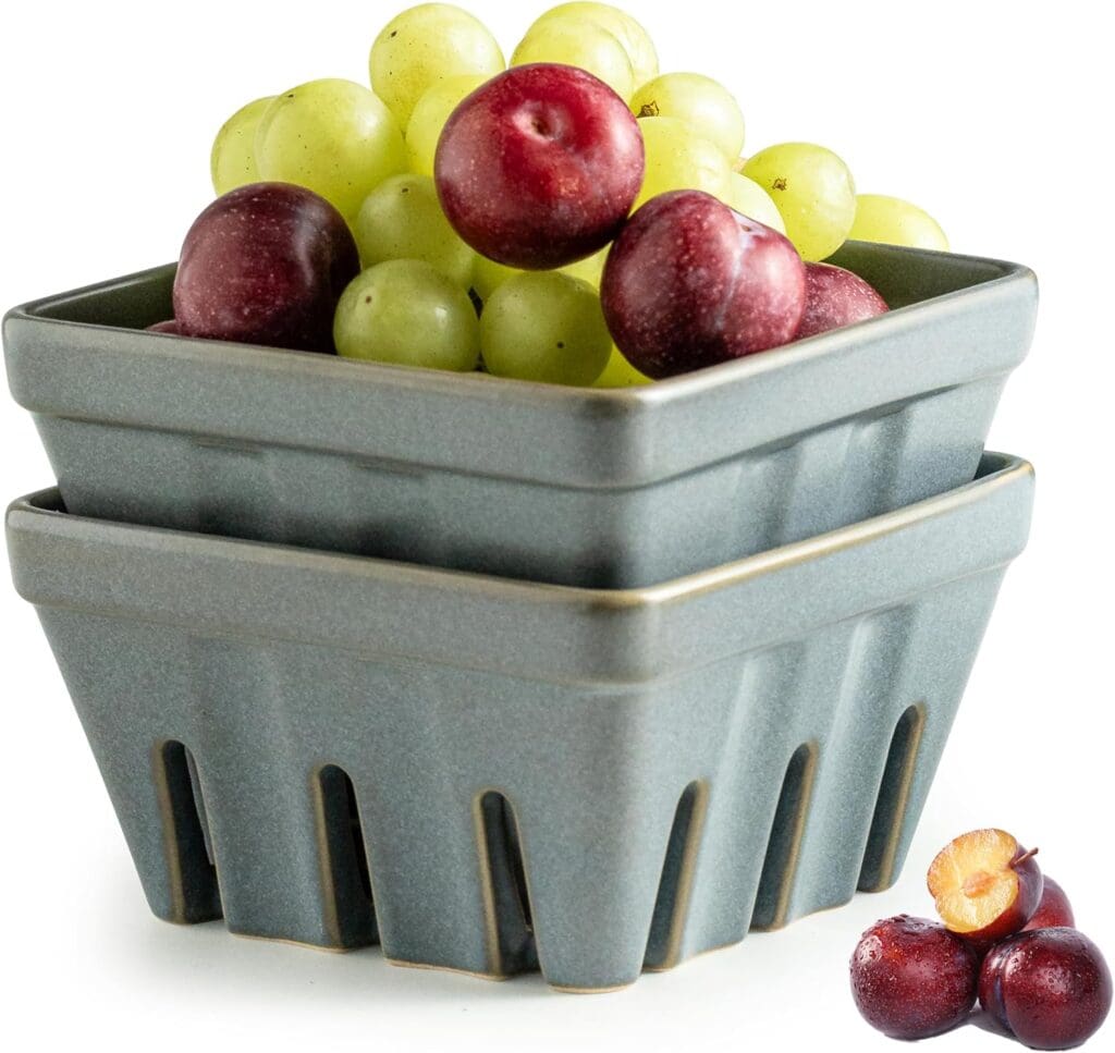 A stack of two square ceramic baskets filled with green grapes and red plums, with additional plums, one cut open, placed beside the baskets—perfect for showcasing your Friday Deals.