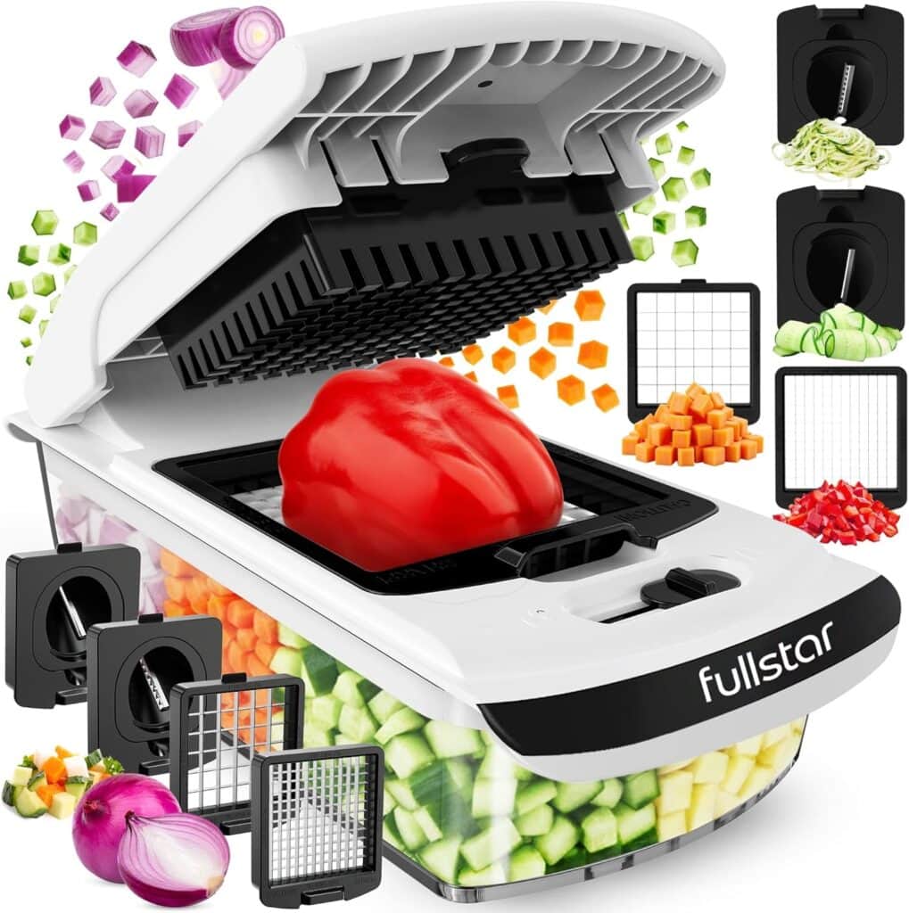 A white Fullstar vegetable chopper with a red bell pepper on the cutting platform, surrounded by diced vegetables and interchangeable blade inserts for slicing and dicing.