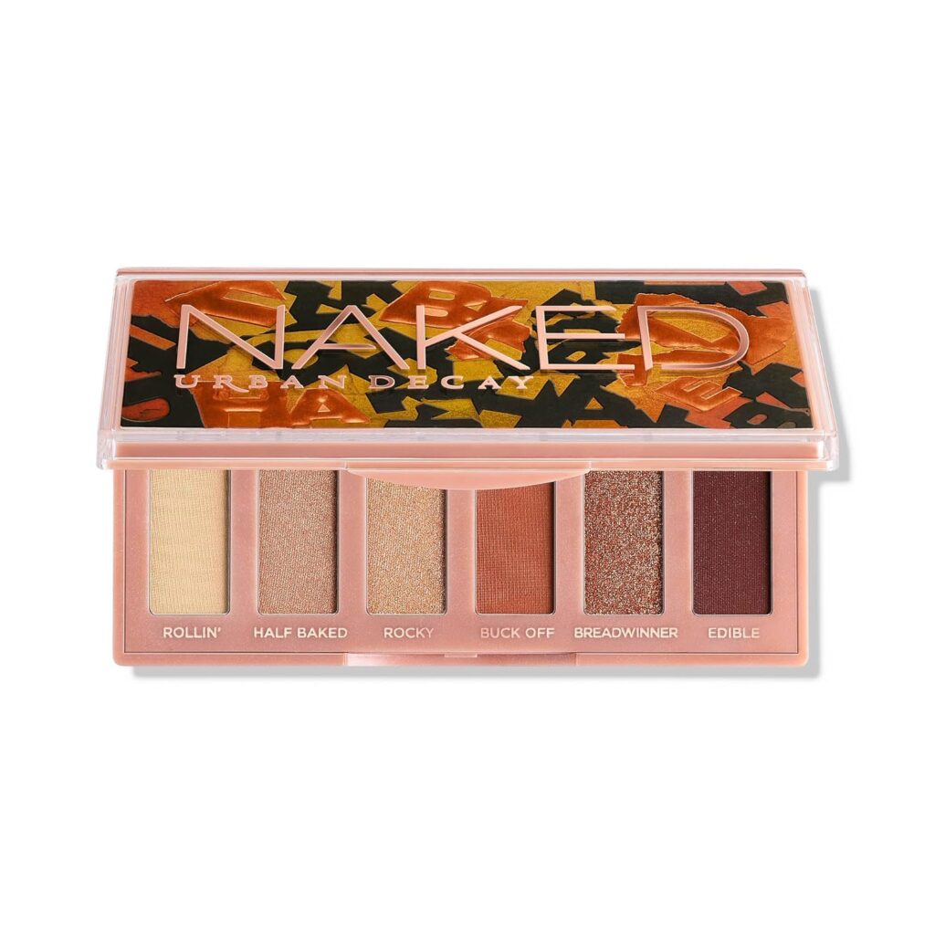 An open Urban Decay Naked eyeshadow palette with six shades from light beige to deep brown. The names of the shades are visible below each color, and the colorful, patterned lid hints at exclusive Tuesday Deals you won't want to miss.