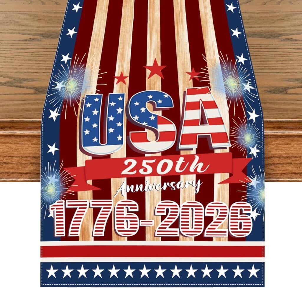 A decorative table runner featuring red and white stripes, blue borders with white stars, and the text “USA 250th Anniversary 1776-2026,” with fireworks graphics and stars—perfect for celebrating with exclusive Wednesday Deals.
