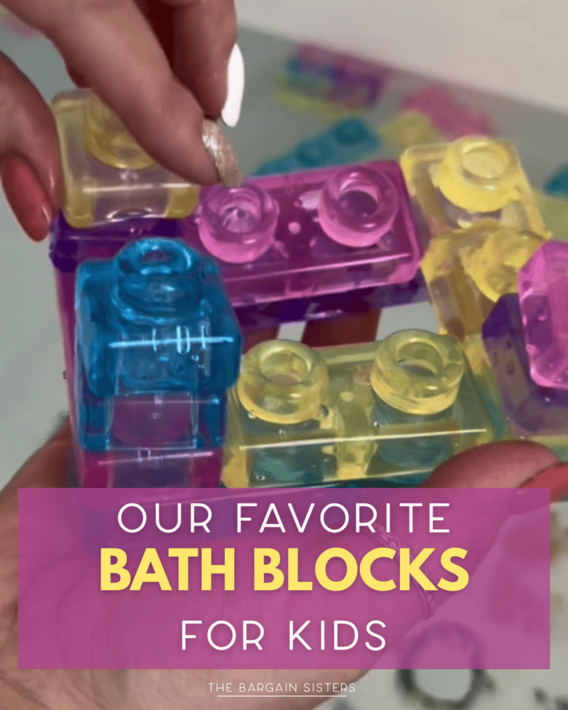 A hand holds colorful, translucent building blocks in blue, pink, and yellow over water. Text overlay reads: "Our favorite bath blocks for kids. The Bargain Sisters.