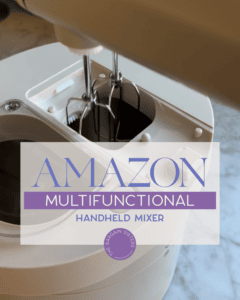 A close-up of a white handheld mixer with beaters, on a marble countertop. Overlaid text reads, "Amazon Multifunctional Handheld Mixer" with a small circular “Bargain Sisters” logo.