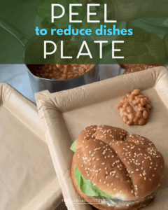 A burger on a bun, a serving of baked beans, and a pot of beans sit on top of a plate lined with brown paper. Text on the image reads, "PEEL to reduce dishes PLATE.