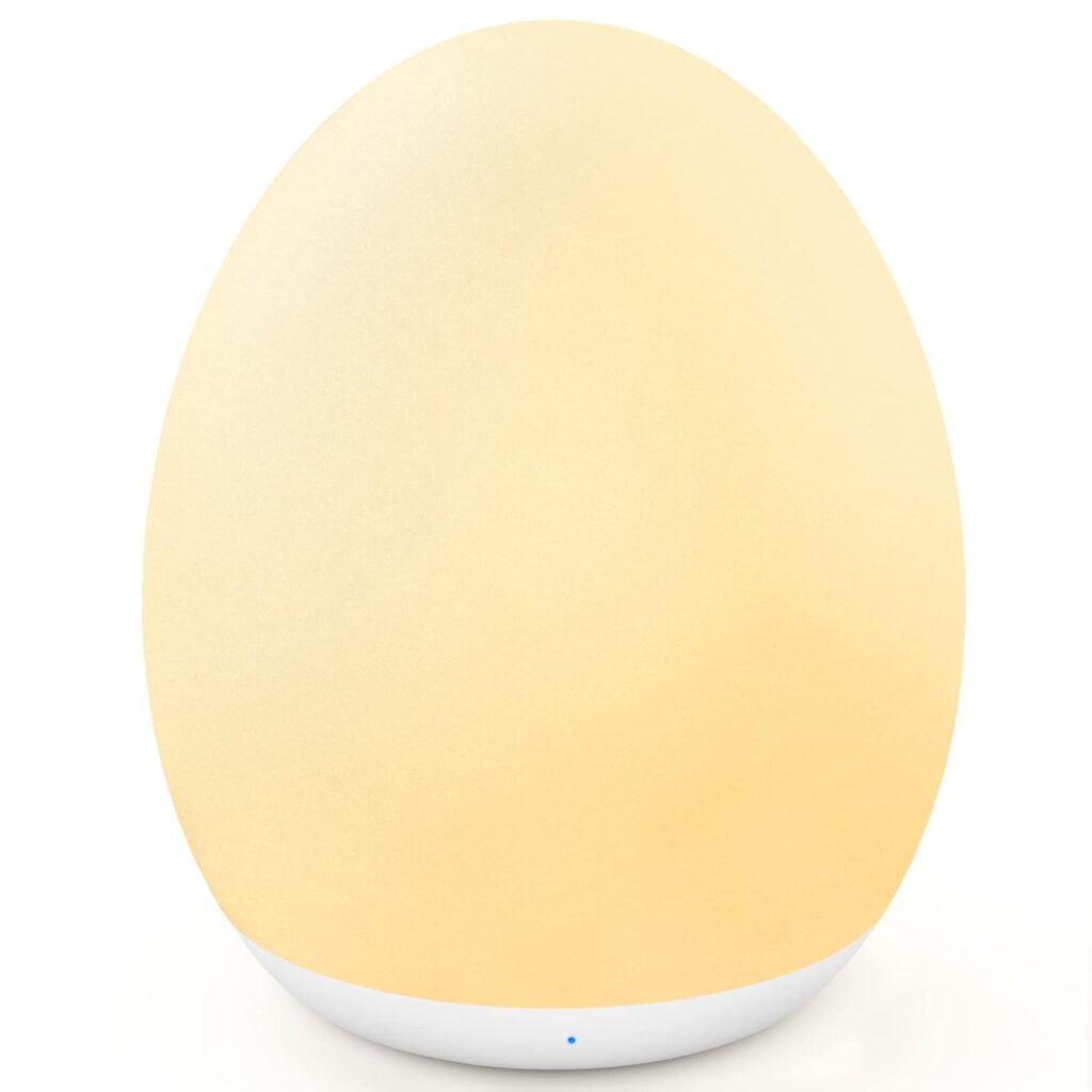 A softly glowing, egg-shaped night light with a smooth, matte surface and a white base, emitting a warm yellow light.