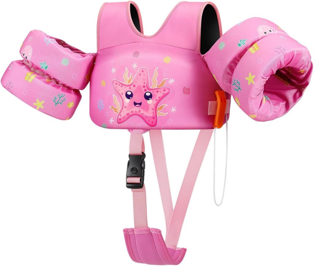 A pink children's swim vest with floatation arm bands, decorated with a smiling starfish, seaweed, and ocean-themed designs. The vest has adjustable straps and a buckle for safety.
