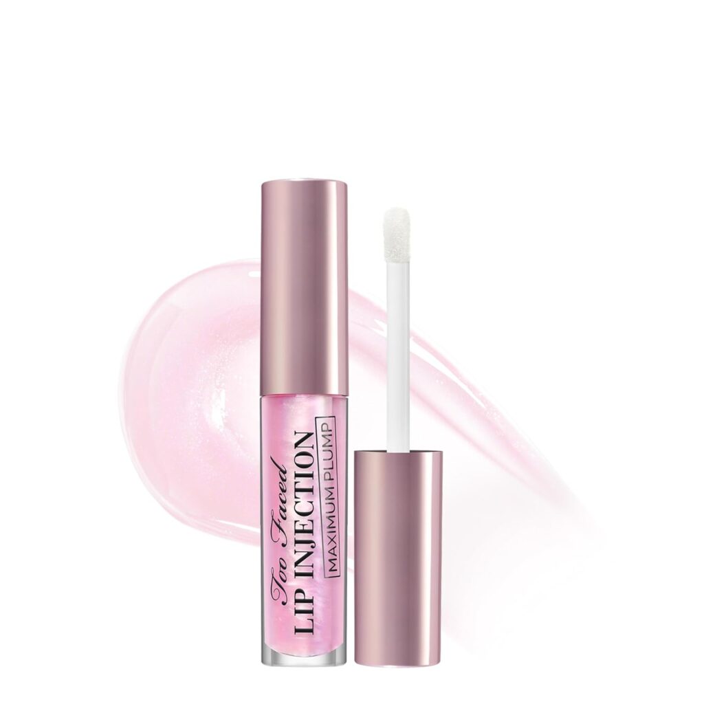 A pink tube of Too Faced Lip Injection Maximum Plump lip gloss with a doe-foot applicator. The gloss has a shiny, iridescent finish, and a swipe of the product is shown in the background.