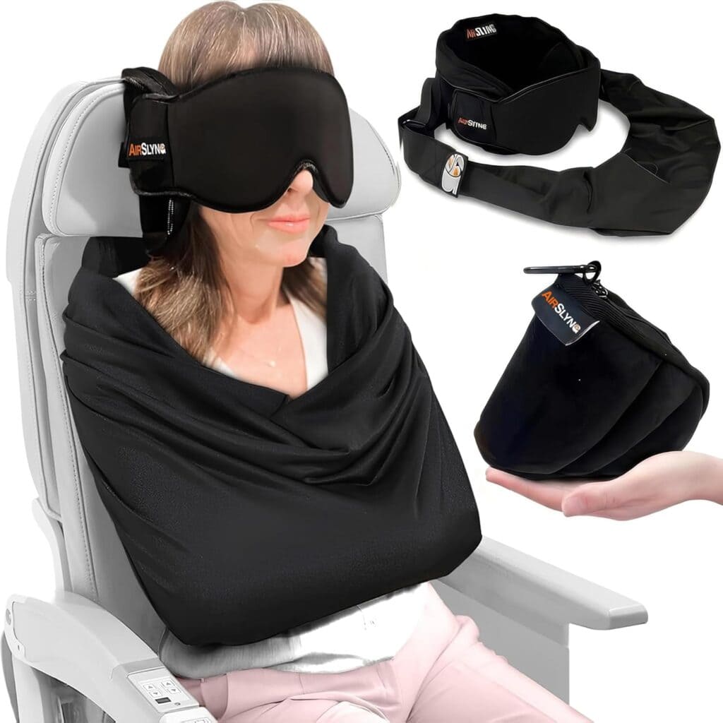 A woman sits in an airplane seat wearing a black sleep mask and a black travel blanket that wraps around her shoulders and arms. Inset images show the blanket folded, worn as a scarf, stored in a compact bag—perfect for scoring Monday Deals.
