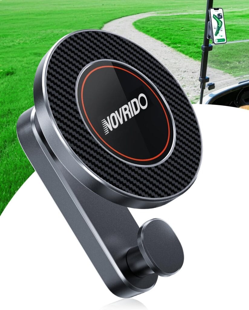 A close-up of a black and silver NOVRIDO magnetic phone holder with a textured circular surface, shown outdoors near a golf cart and a green grassy path.