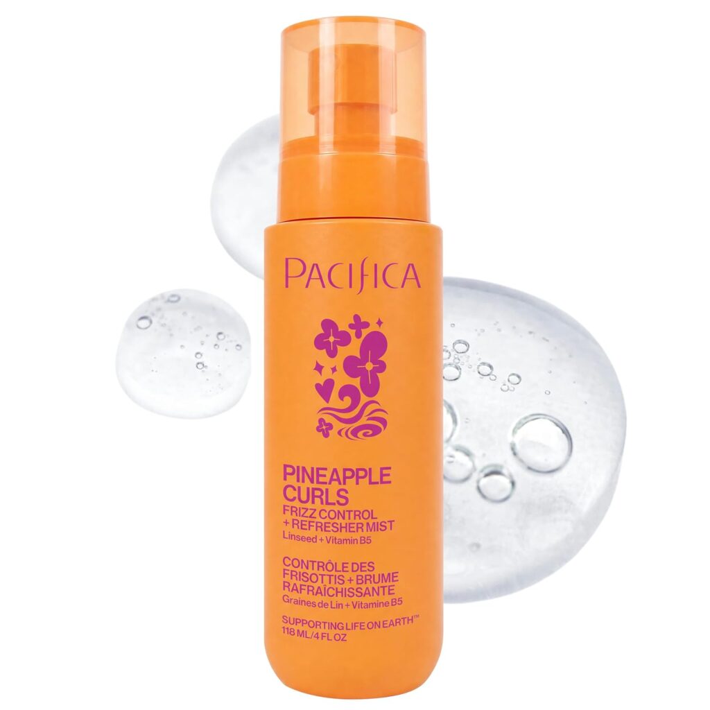 An orange bottle of Pacifica Pineapple Curls Frizz Control & Refresher Mist is shown in front of clear liquid drops on a white background, highlighting the purple text and floral designs—perfect for your next Thursday Deals haul.