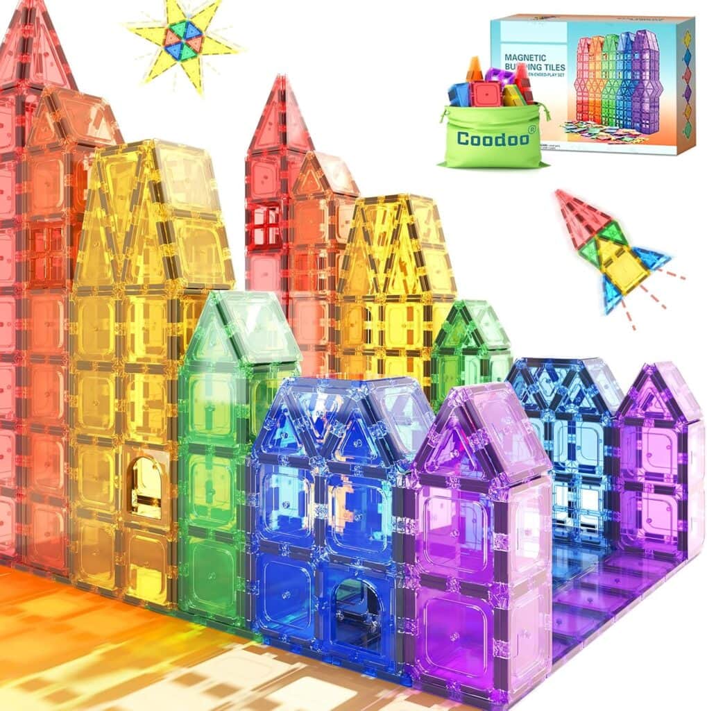 Colorful magnetic building tiles stacked to form various structures; a green storage bin, product box, and loose tiles appear in the background—perfect for creative play and now available as part of our exclusive Tuesday Deals.