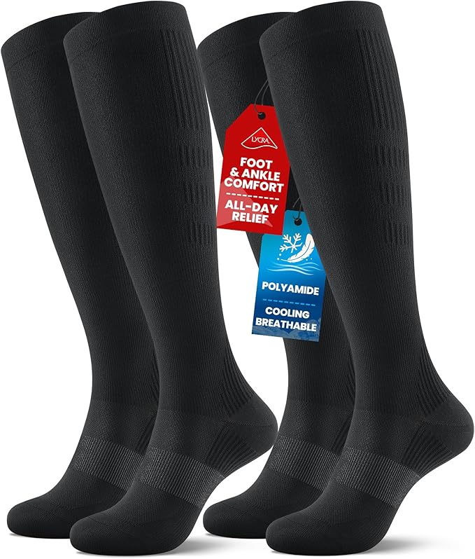 Four pairs of long black cooling compression socks stand upright. Tags highlight features such as “foot & ankle comfort,” “all-day relief,” “polyamide,” and “cooling, breathable.” Perfect for all-day wear and support.