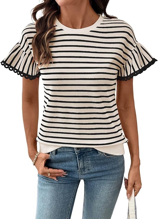 A woman wearing a short-sleeve, white knit top with black horizontal stripes and ruffled sleeves with scalloped edges, paired with blue jeans.