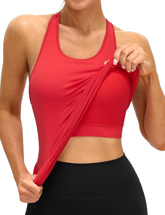 A woman wearing a red athletic tank top and black leggings lifts part of her tank top, revealing the matching red sports bra underneath. The background is plain white—perfect for showcasing Wednesday Deals on activewear.