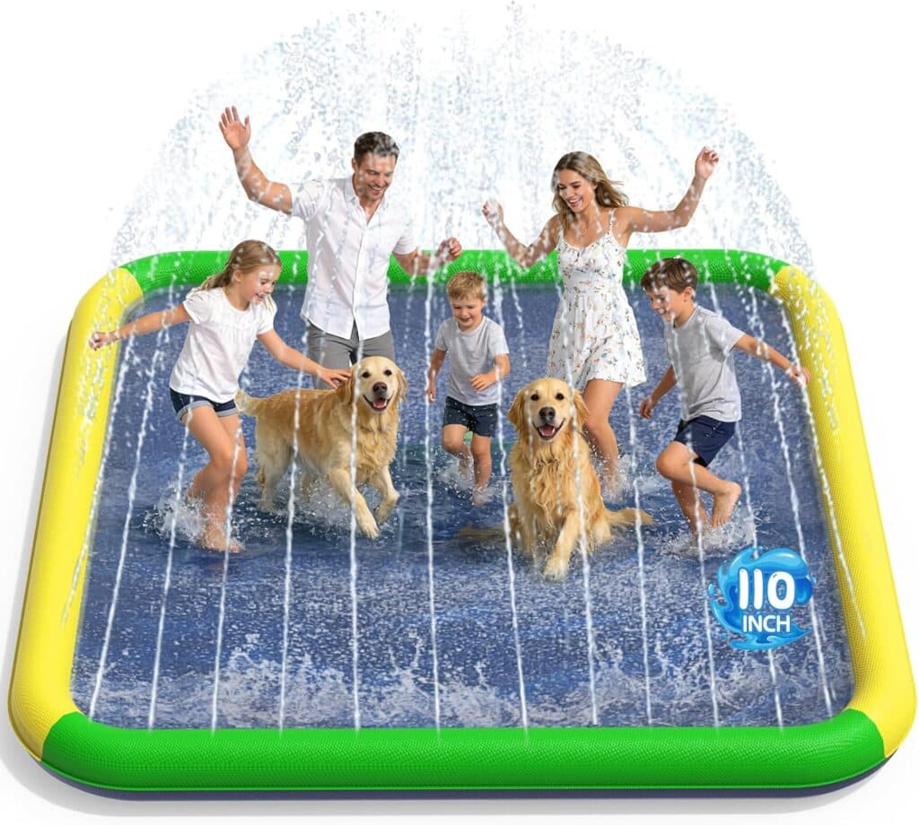 A family of four and two golden retrievers play and splash in a large, square inflatable splash pad with water spraying up around them. The splash pad has green, yellow, and blue edges and measures 110 inches.