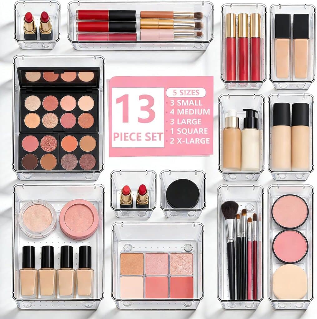 Clear acrylic makeup organizer set holding various cosmetics, including lipsticks, brushes, powders, palettes, and foundation bottles. Central text highlights “13 piece set” with 5 different container sizes arranged neatly.