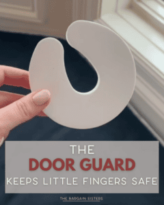 A hand holds a white, C-shaped foam door guard near a window. Text overlay reads, “The door guard keeps little fingers safe. The Bargain Sisters.”.